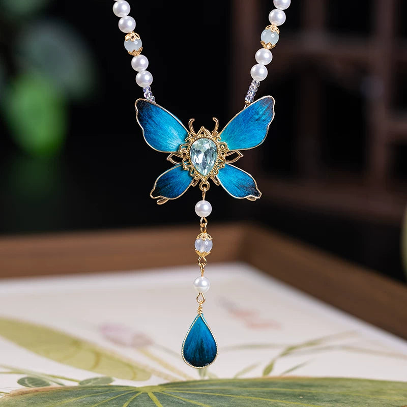 Blue butterfly pendant necklace with glass center and teardrop accent