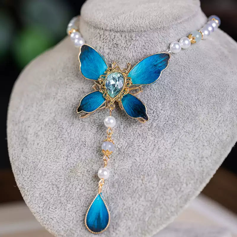 Blue butterfly pendant necklace displayed on a necklace bust