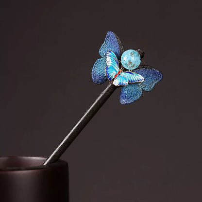 Blue butterfly hairpin with a dark wooden stick and glass accent