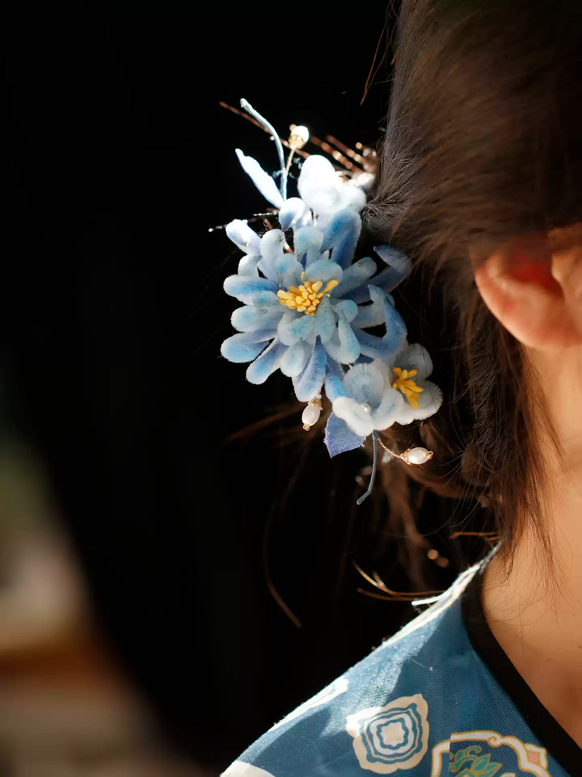 Side profile of the blue chrysanthemum hair ornament when worn