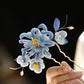 Close detail of the blue chrysanthemum flower and dangling accents