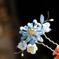 Blue chrysanthemum hairpin shown worn in an elegant updo