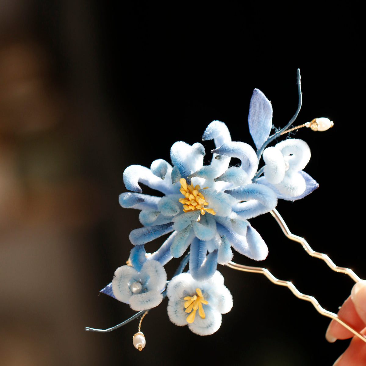 Blue chrysanthemum hairpin shown worn in an elegant updo