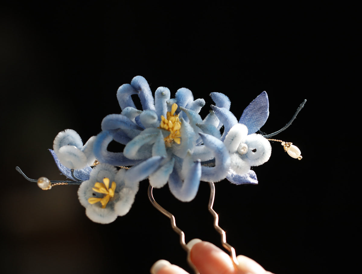 Blue chrysanthemum hair ornament worn in an updo