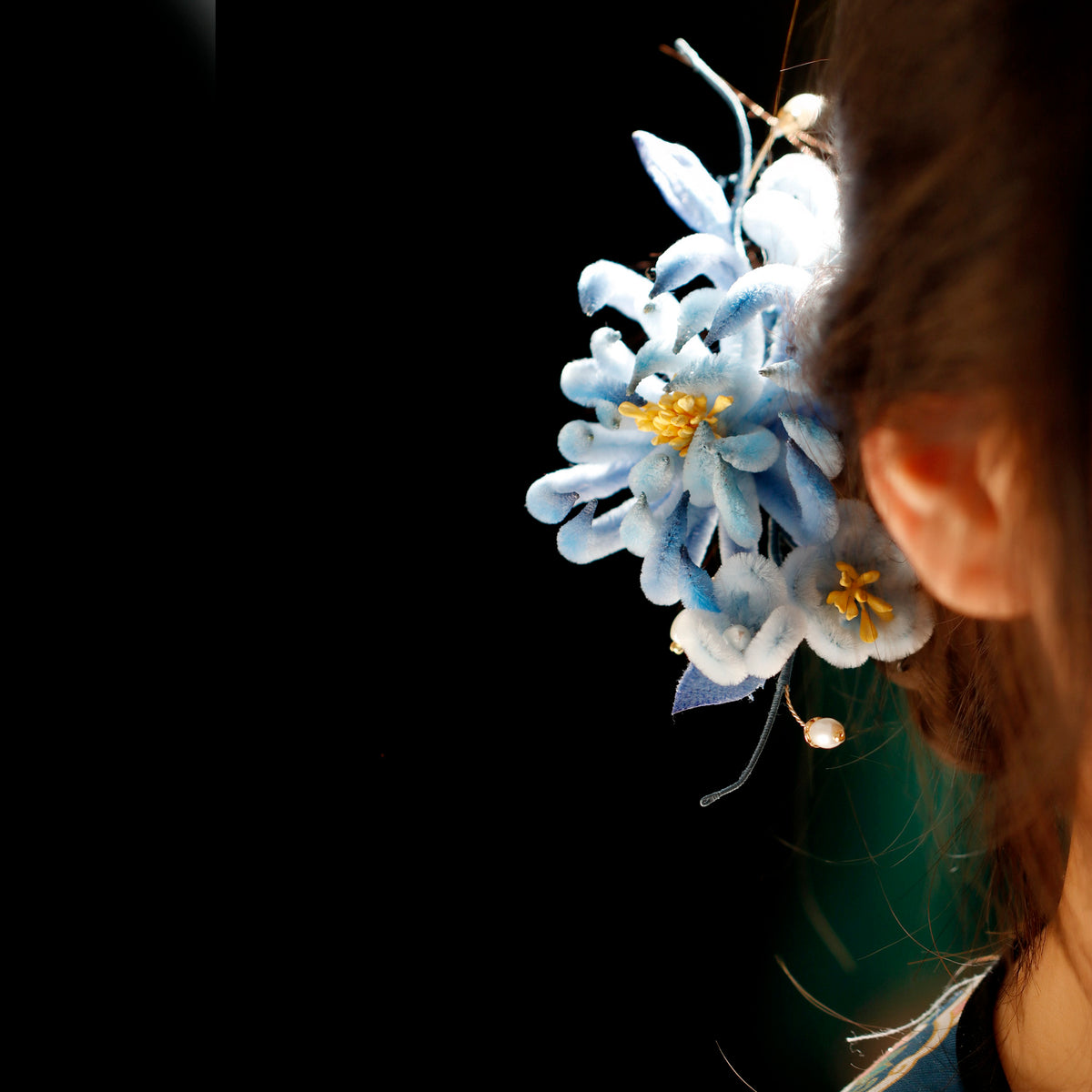 Blue chrysanthemum hairpin styled in dark hair