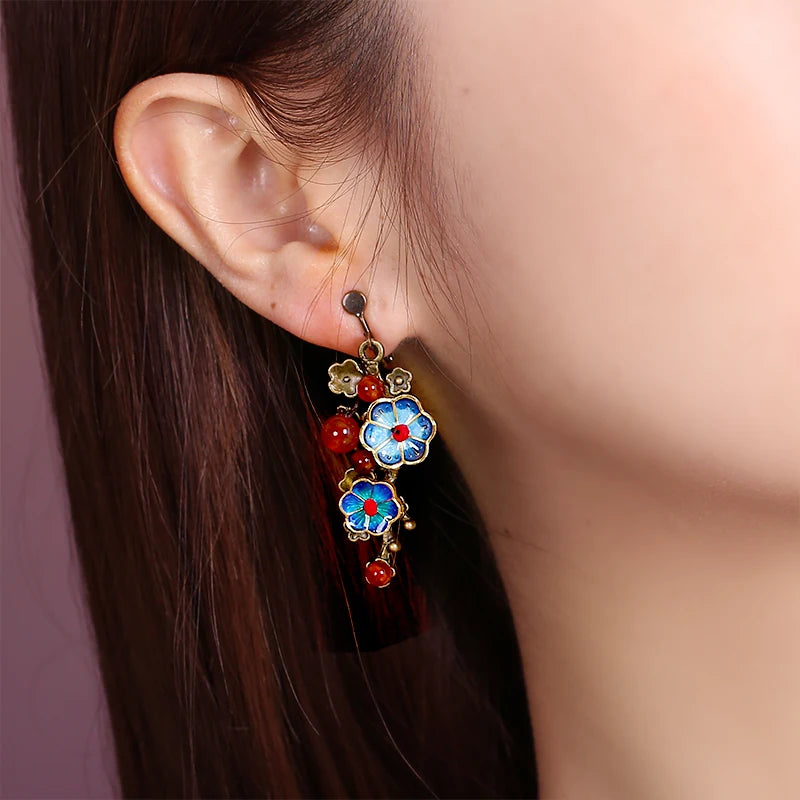 Blue floral cloisonne and red agate clip-on earring worn on the ear
