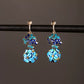 Blue floral drop earrings with gold-tone clip-on fasteners