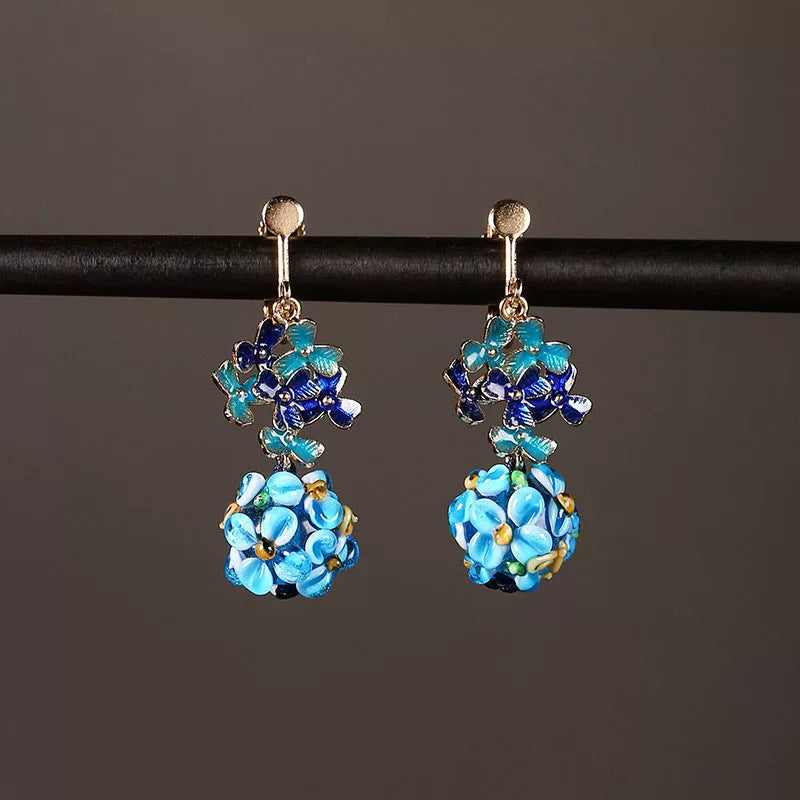 Blue floral drop earrings with gold-tone clip-on fasteners