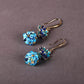 Side view of blue floral drop earrings showing the long ear hooks