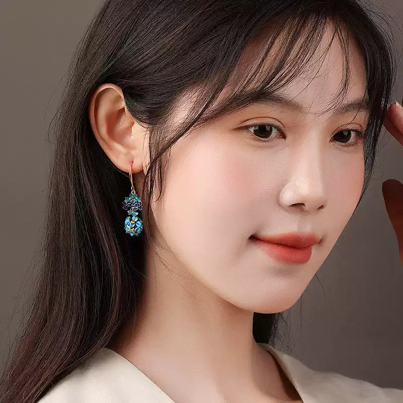 Close-up of the blue floral drop earring worn with dark hair