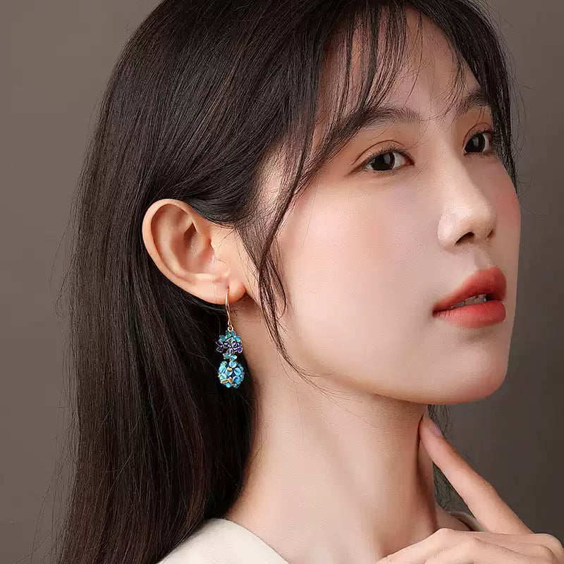 Blue floral drop earring shown worn in profile