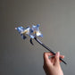 Horizontal view of handmade blue iris floral hair stick