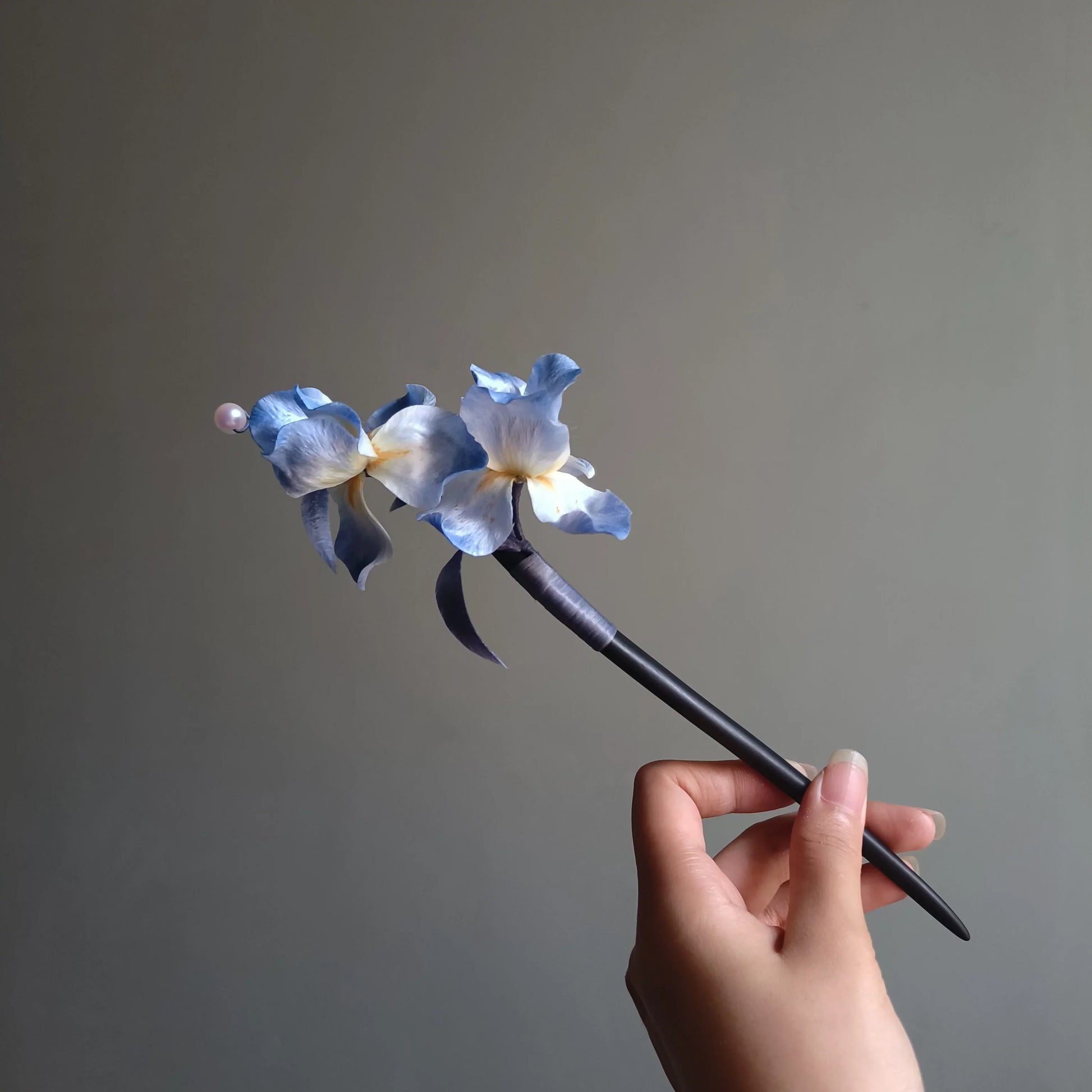 Horizontal view of handmade blue iris floral hair stick