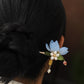 Blue magnolia hairpin styled in a dark hair bun