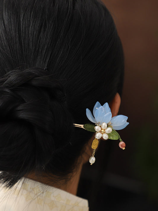 Blue magnolia hairpin styled in a dark hair bun