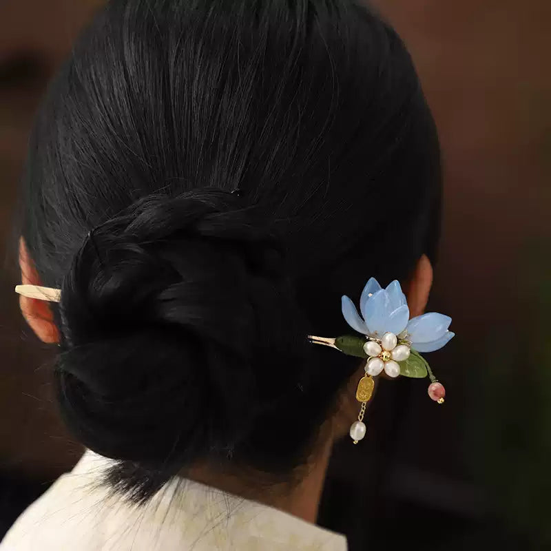 Blue magnolia hair stick worn in an updo