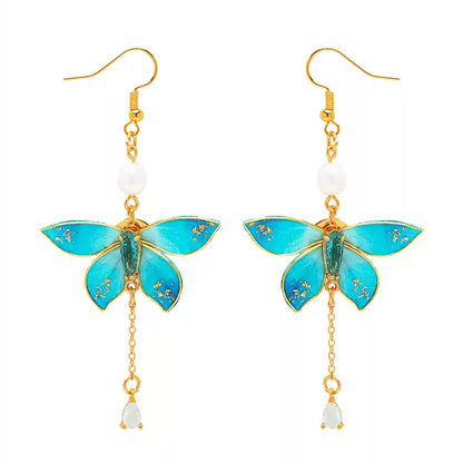 Pair of blue butterfly drop earrings with freshwater pearl accents and ear hooks