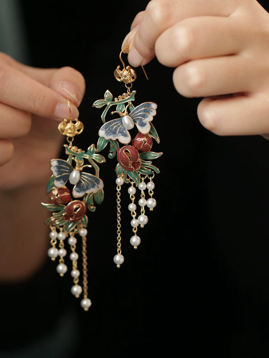 Red Vine color butterfly tassel earrings on dark display