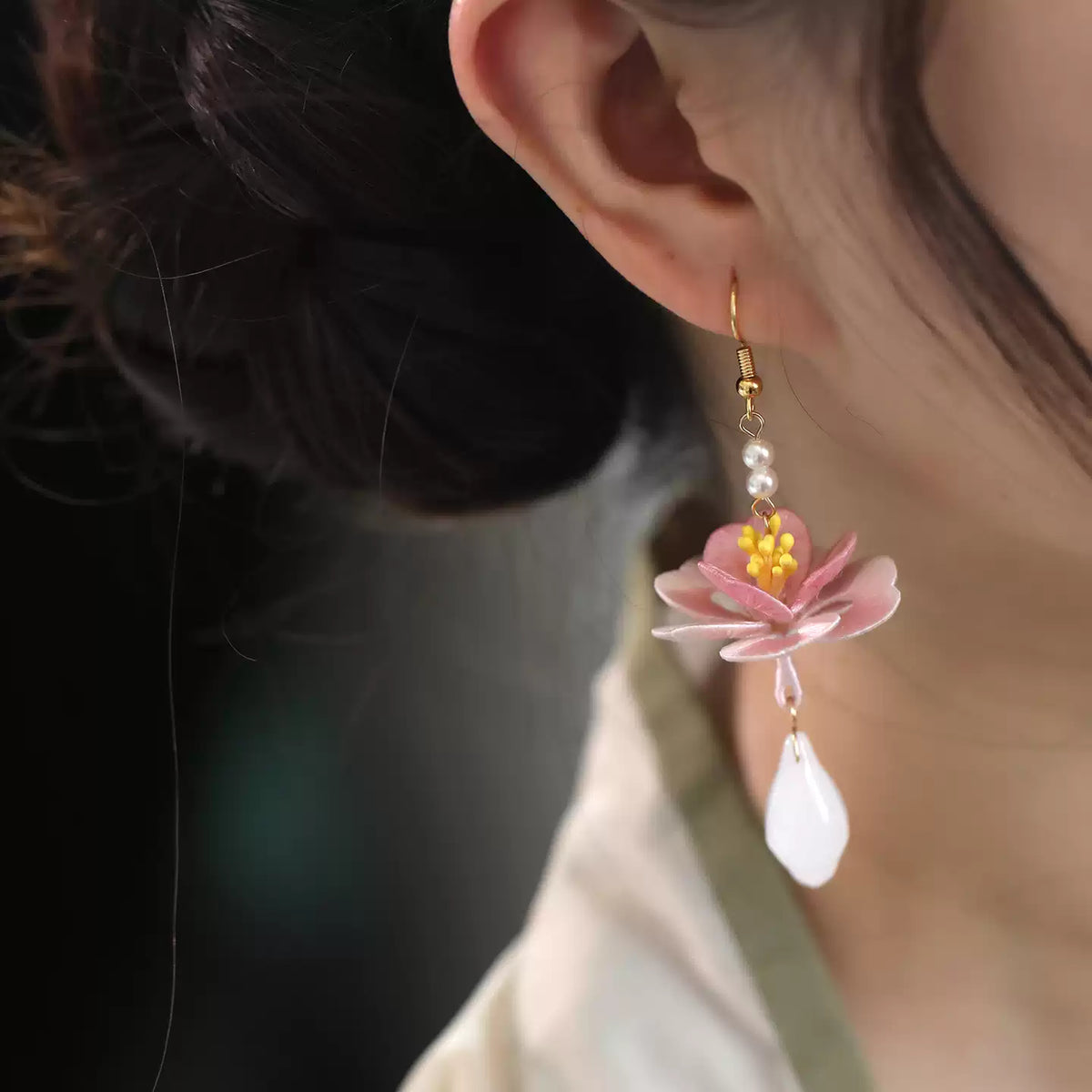 Hand-wrapped lotus earring worn with a dark outfit
