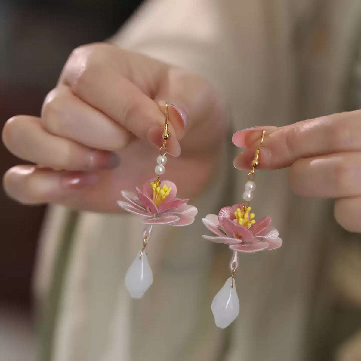 Close view of lotus drop earrings worn