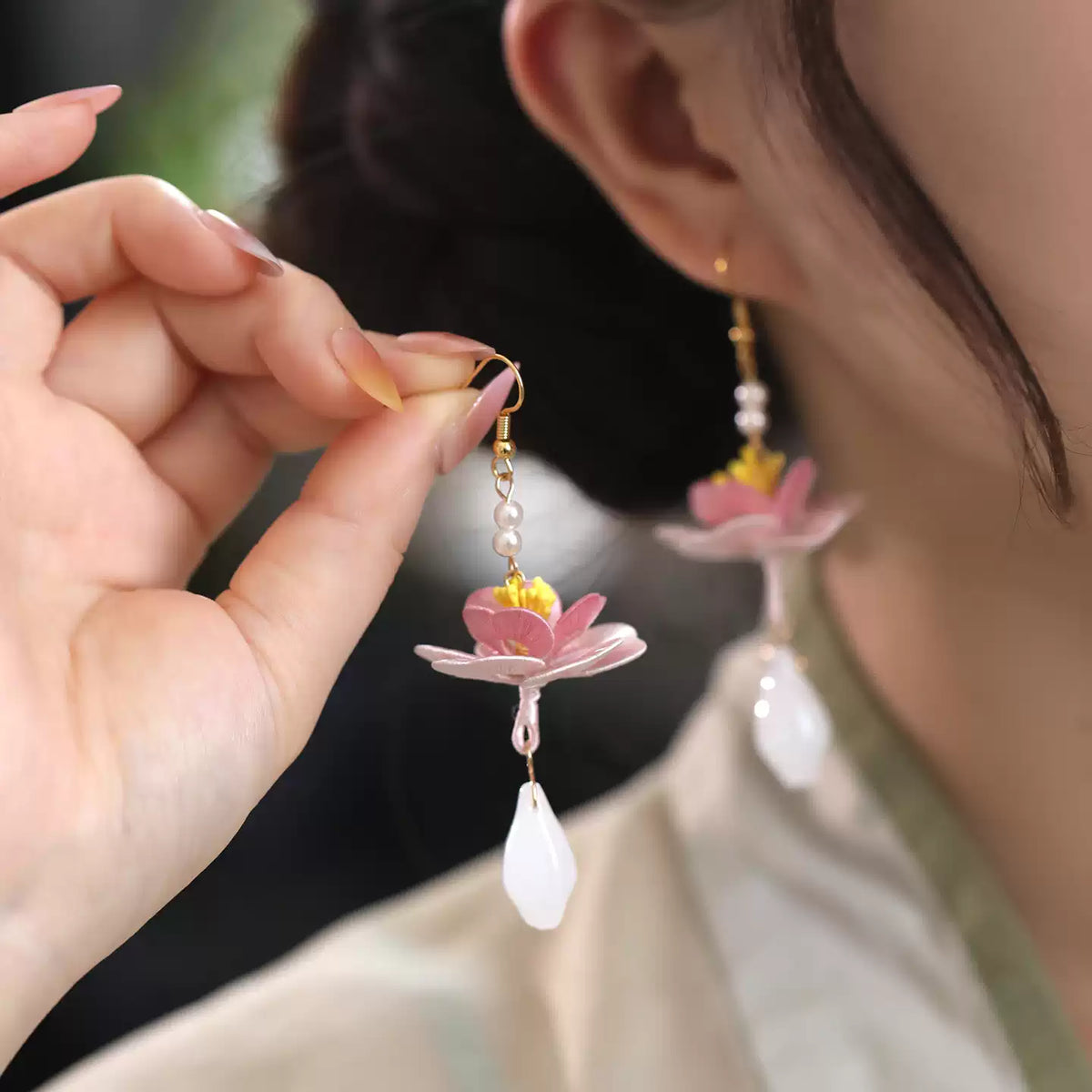 Lotus earrings shown beside a model wearing one