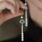 Close-up of the turquoise cloud-inspired earring with red center and white bead tassel