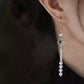 Turquoise and white bead tassel earring worn, side view