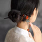 Red sandalwood hairpin styled in a low bun