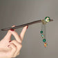 Close view of the hair stick and decorative dangling chains