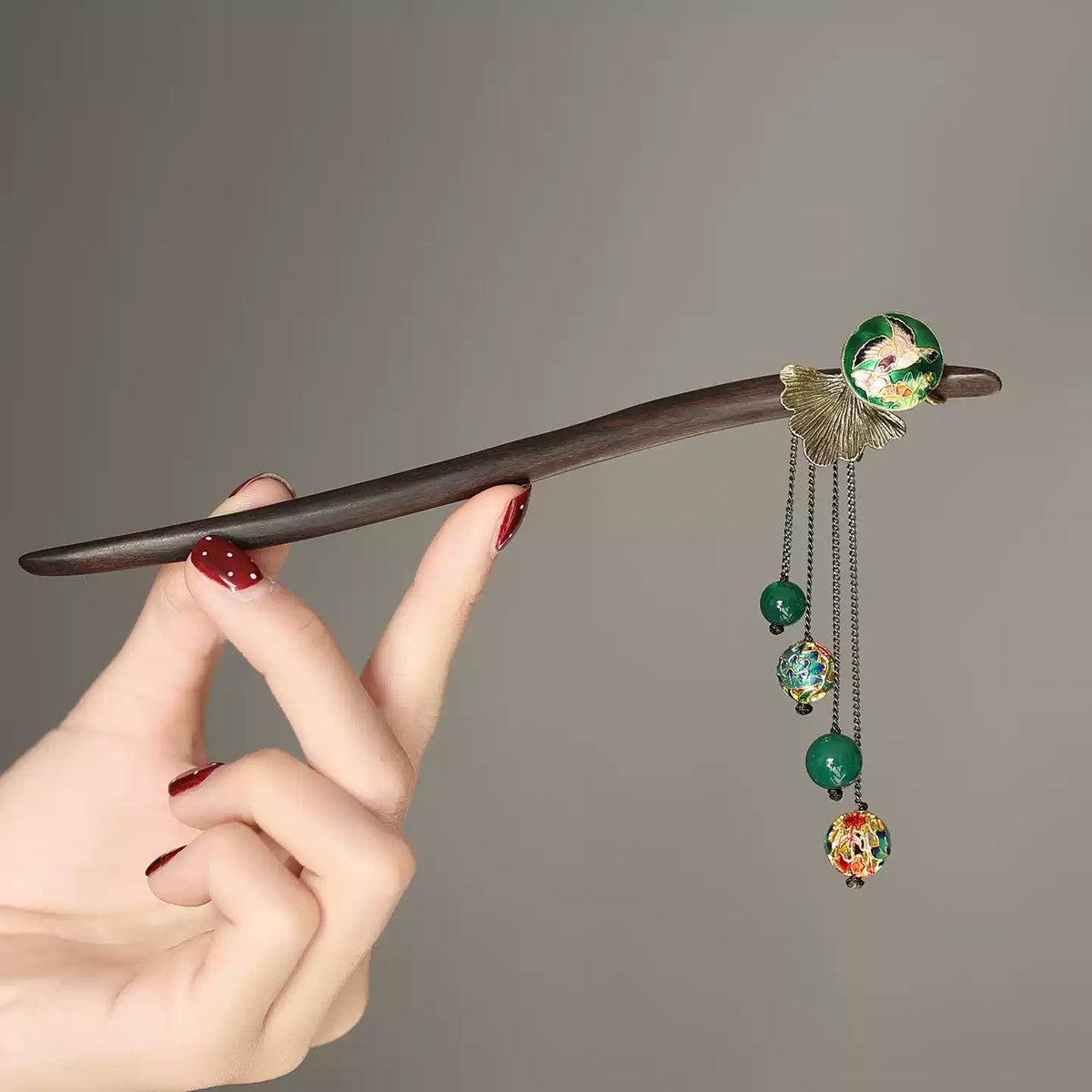 Close view of the hair stick and decorative dangling chains