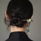 Chinese-inspired dark wood hair stick styled in a low bun