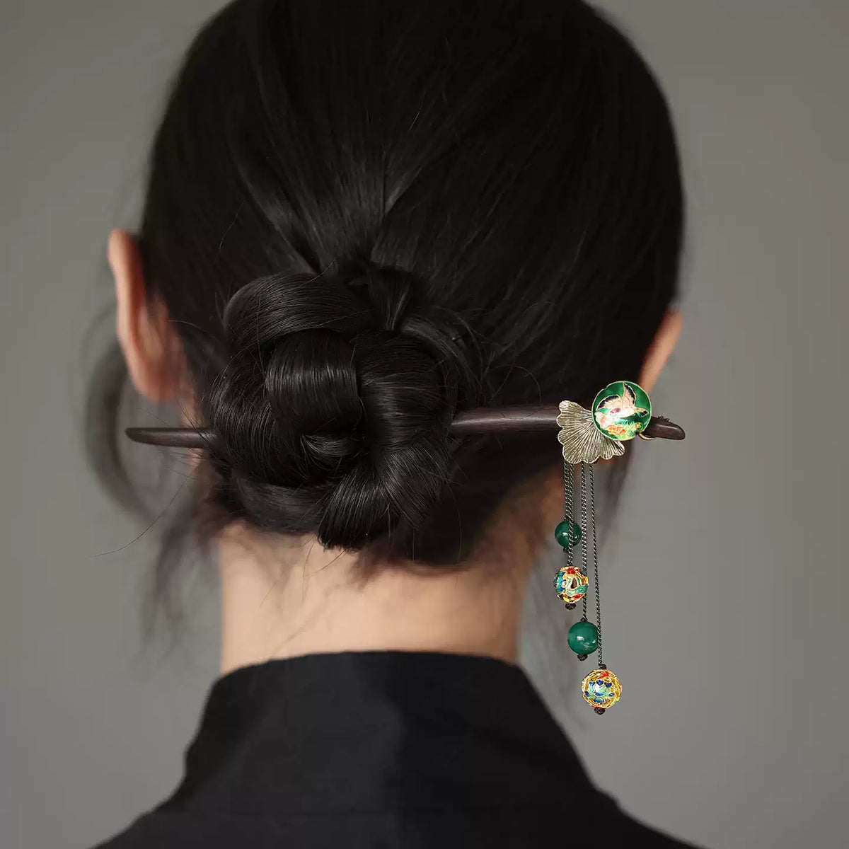 Chinese-inspired dark wood hair stick styled in a low bun