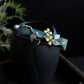 Deep blue brocade hair clip displayed against a dark background