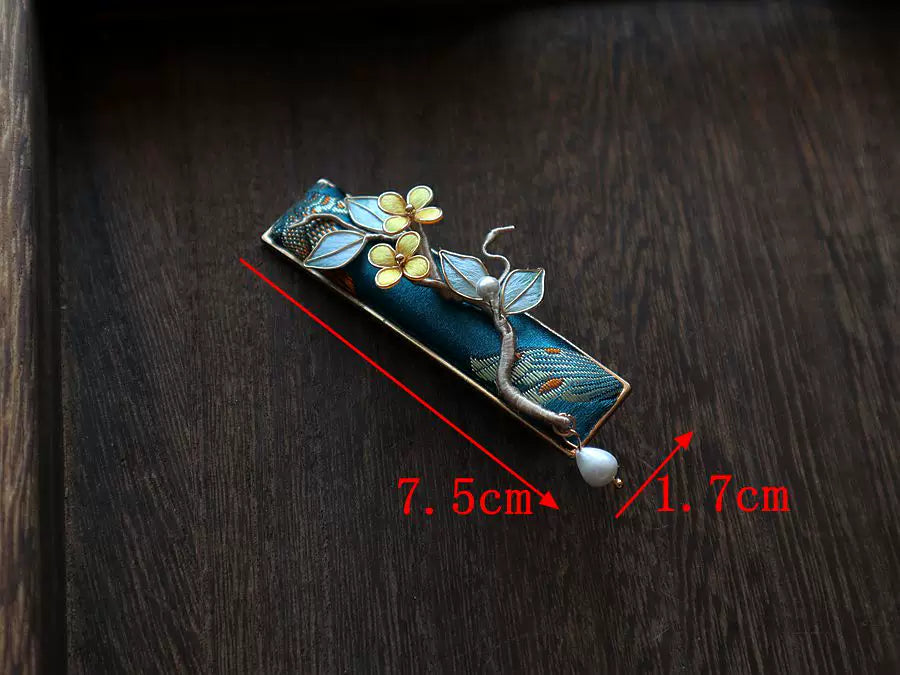 Close-up of the deep blue floral hair clip held in hand for scale