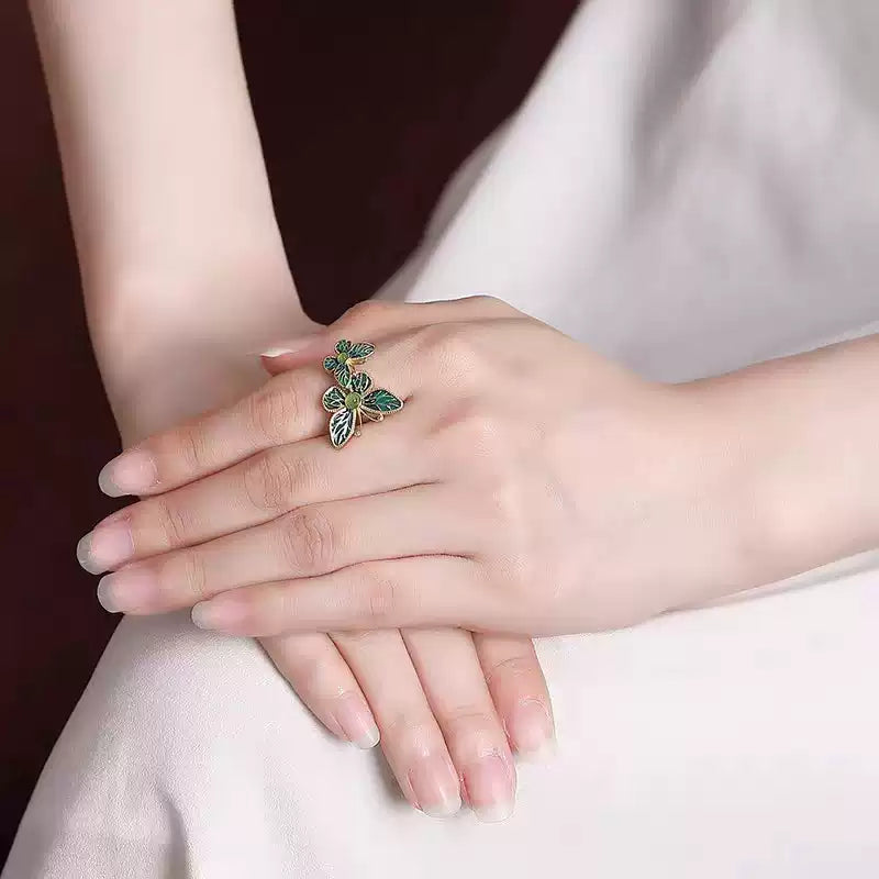 Double butterfly ring worn on a hand for scale