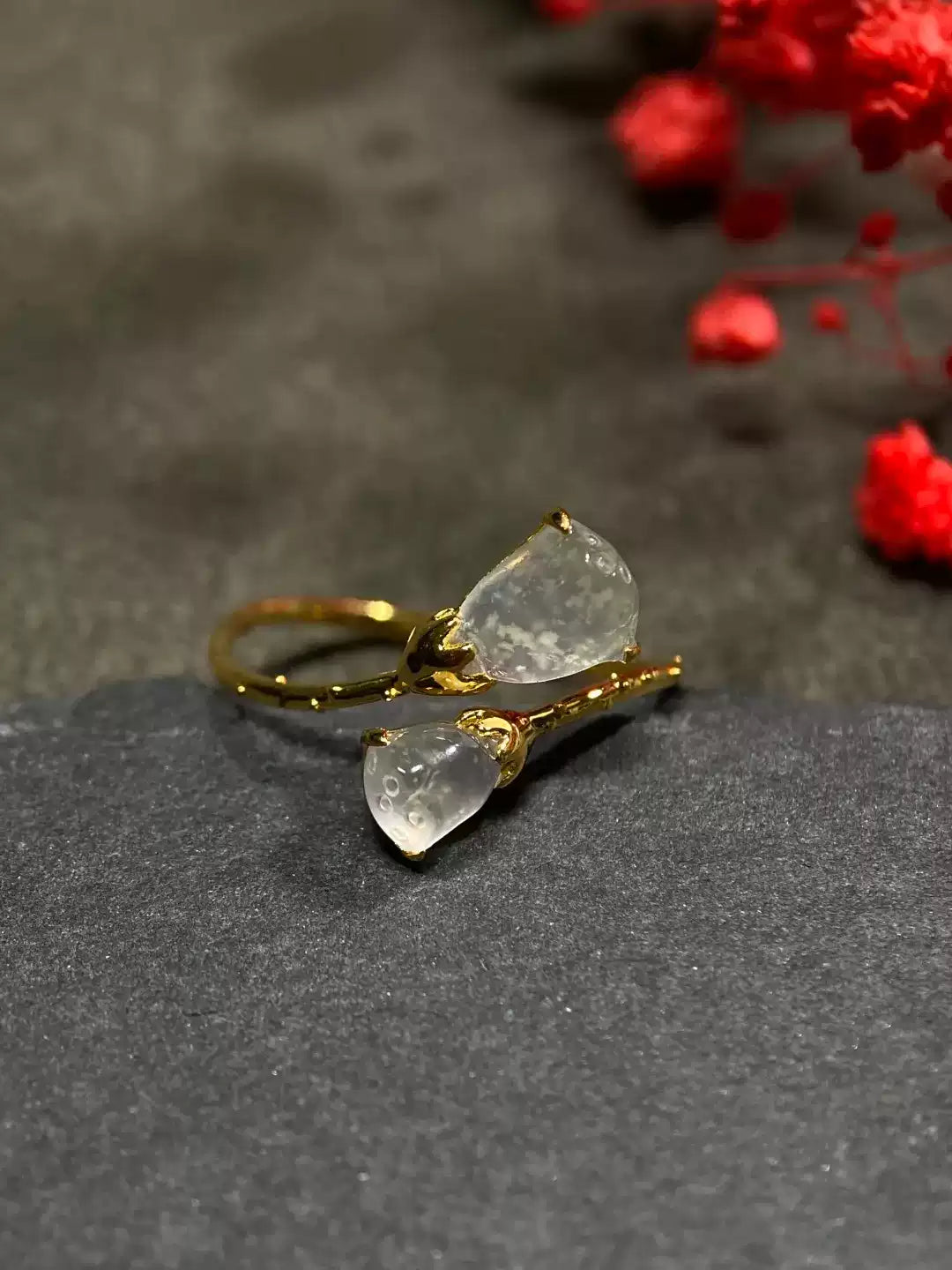 Close detail of the translucent lotus pod forms and gold-tone band
