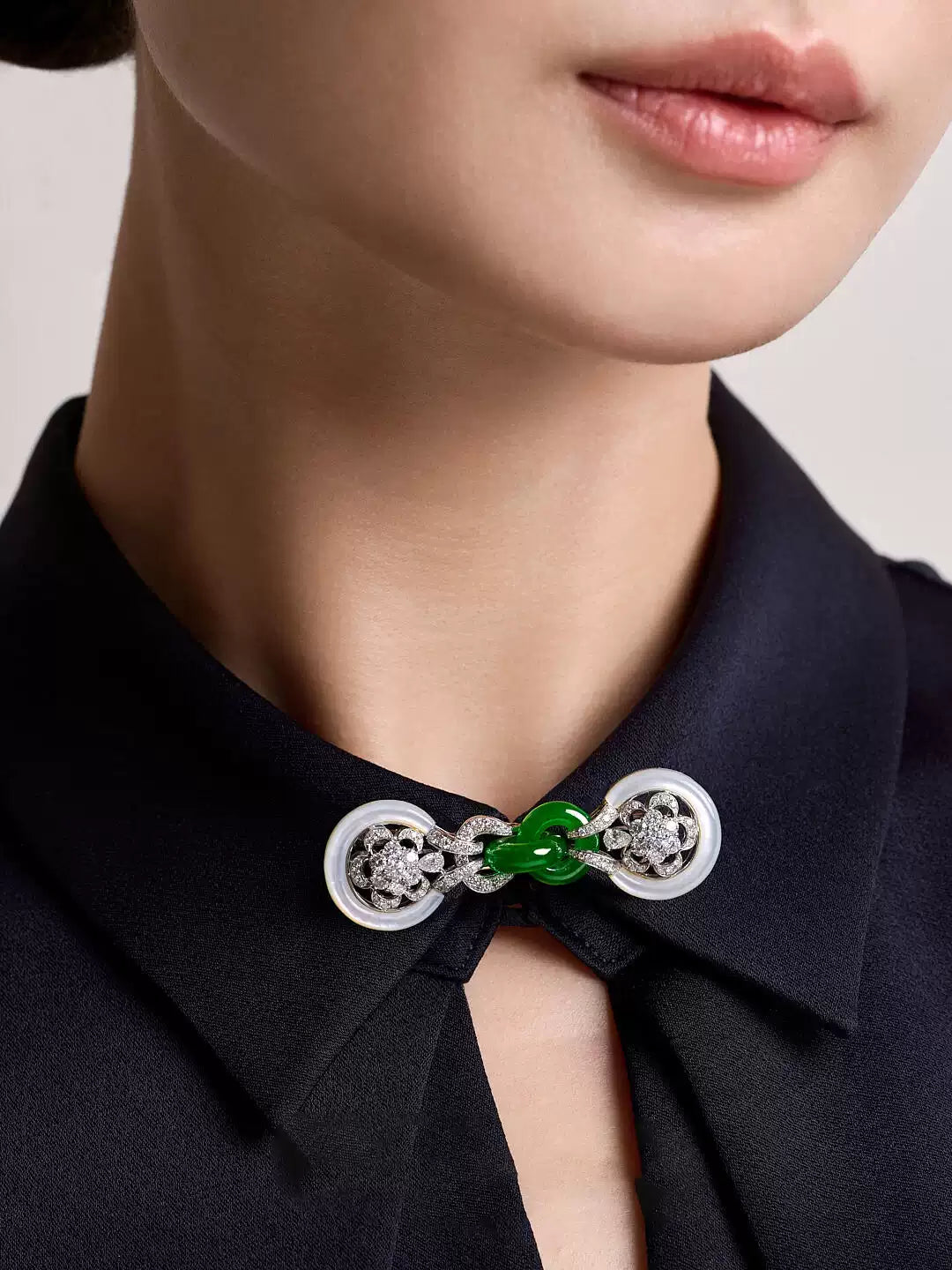 Close-up of the green faux-jade center and pale circular details on the collar brooch