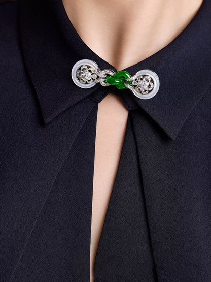 Green faux-jade Chinese knot collar brooch shown on a dark shirt