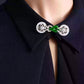 Faux-jade Chinese-style collar brooch worn at the neckline of a dark blouse