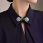 Collar brooch with a green faux-jade centerpiece styled on a black collared shirt