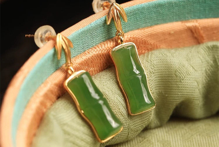 Close-up of the green bamboo segment earrings showing their gold-plated bamboo tops
