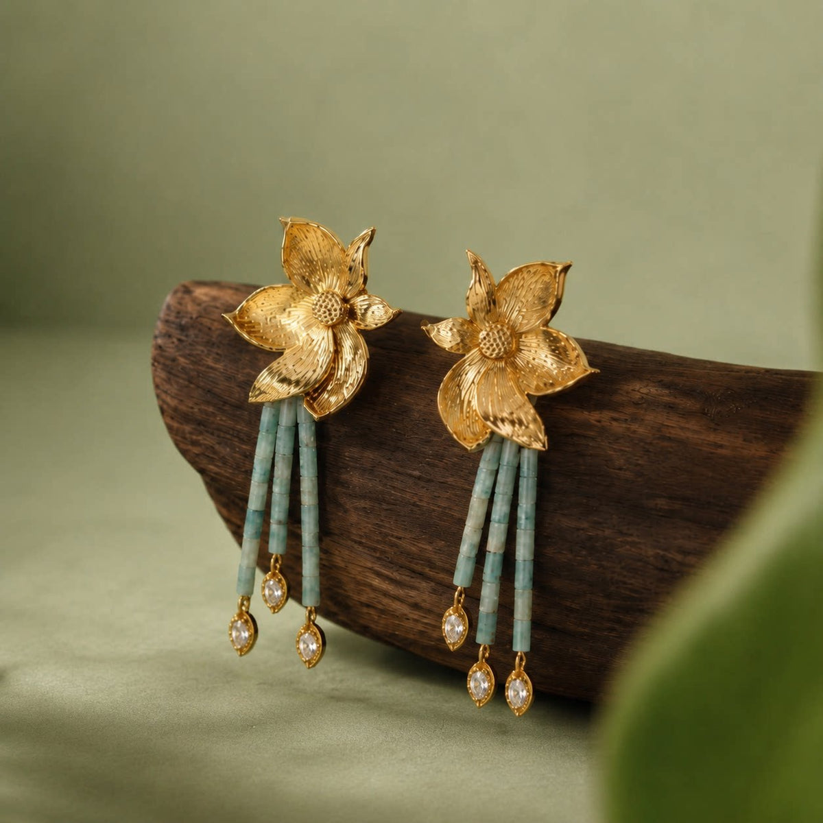 Pair of floral stud earrings displayed on a dark wood stand