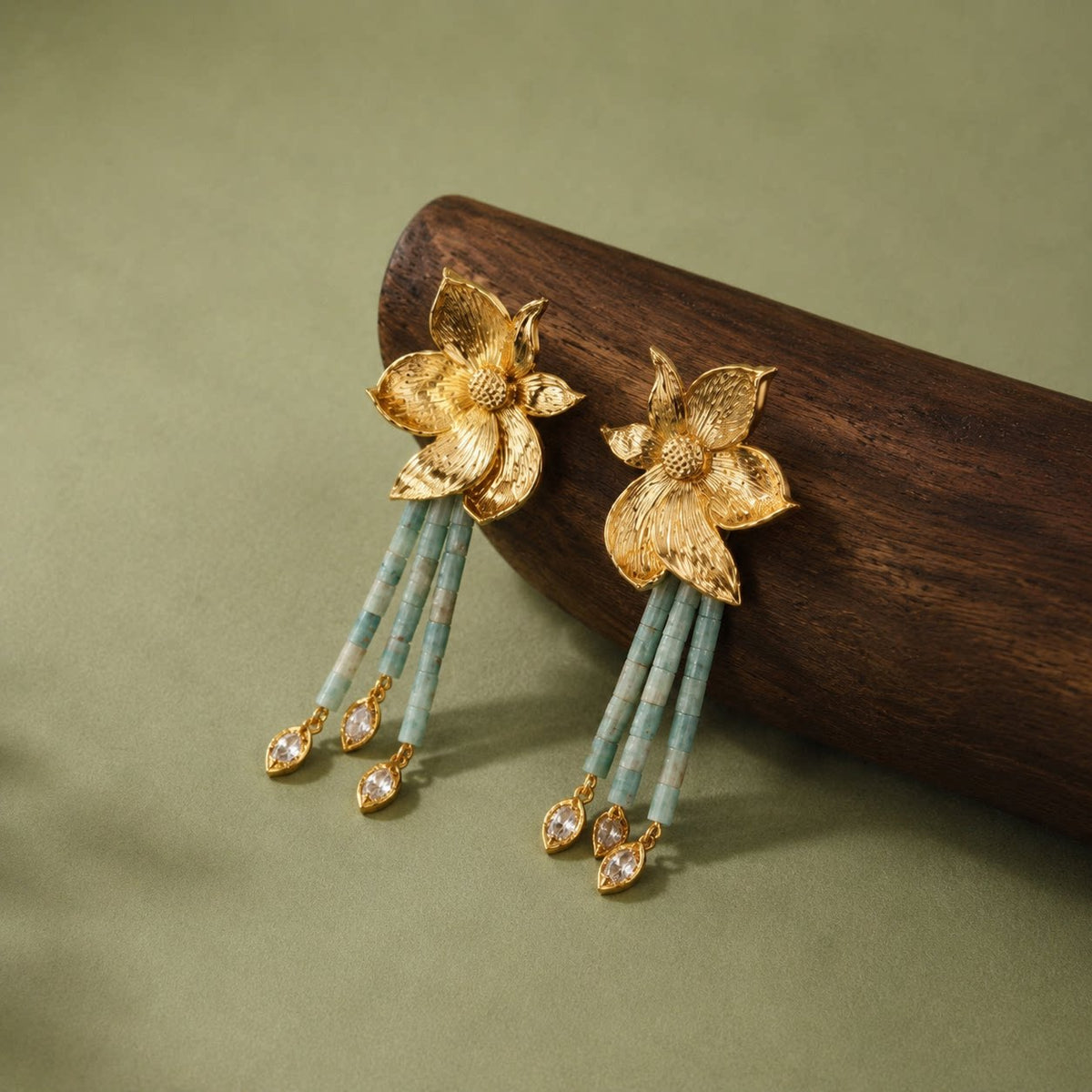 Angled view showing the flower relief, pale green beads, and dangling accents