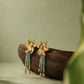 Pair of gold-tone floral stud earrings with pale green bead tassels and clear teardrop accents