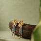 Pair of gold-tone flower earrings with pale green bead strands and dangling clear accents