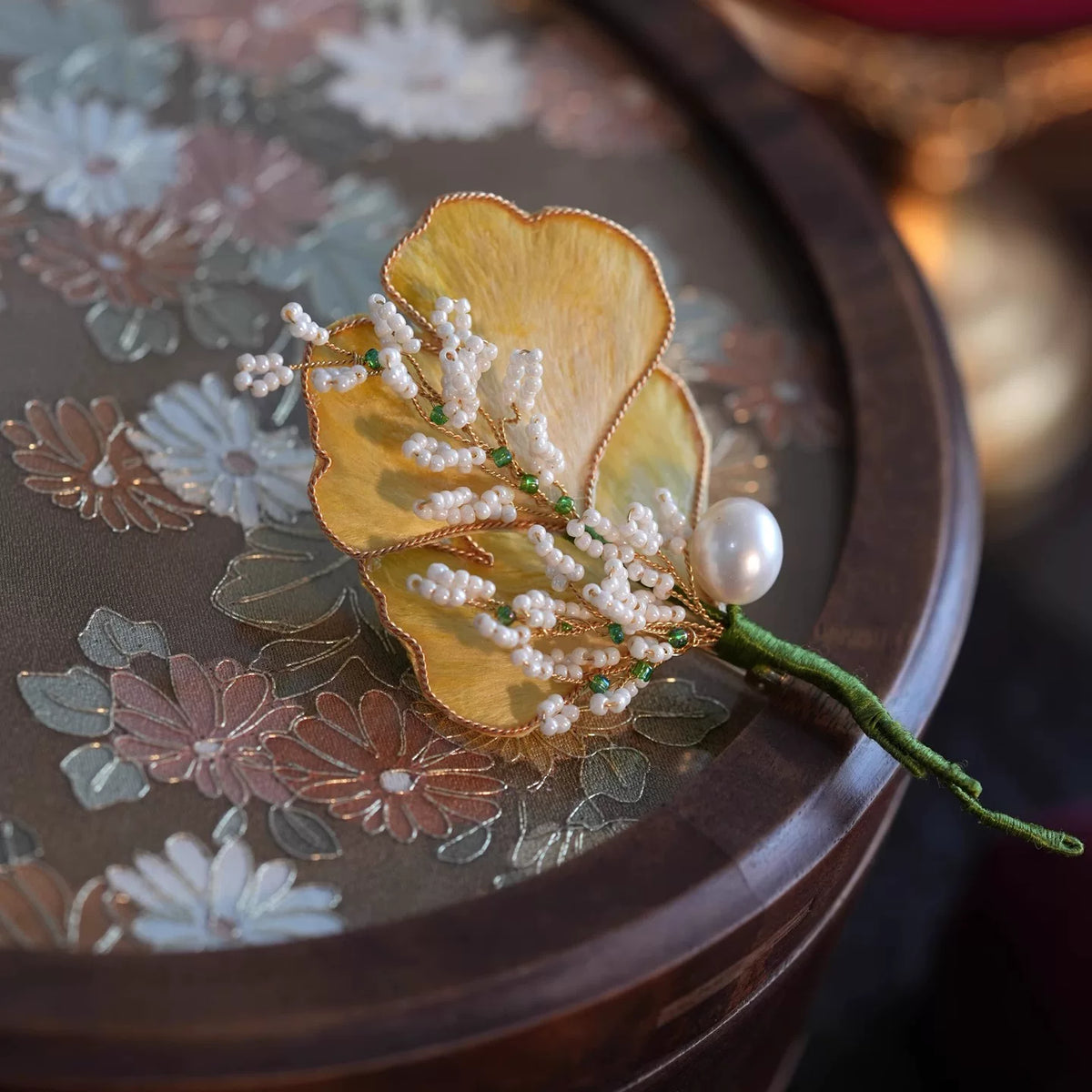 Full view of the ginkgo leaf floral brooch displayed upright
