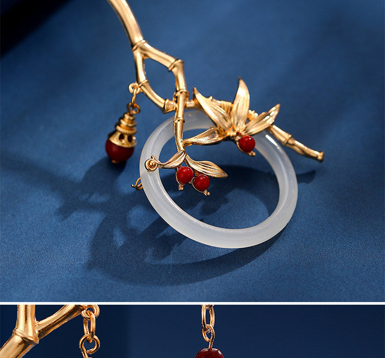Gold bamboo orchid hairpin detail with red beads and circular ornament
