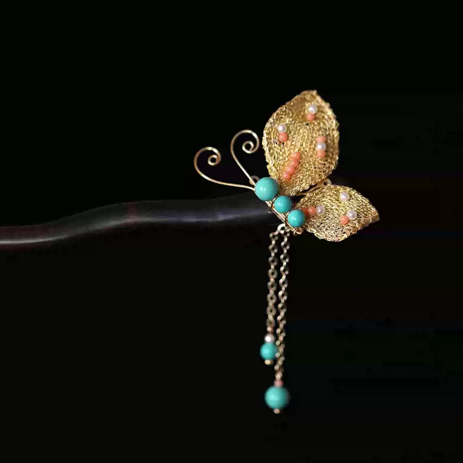 Close-up of the handwoven gold butterfly ornament and dangling accents