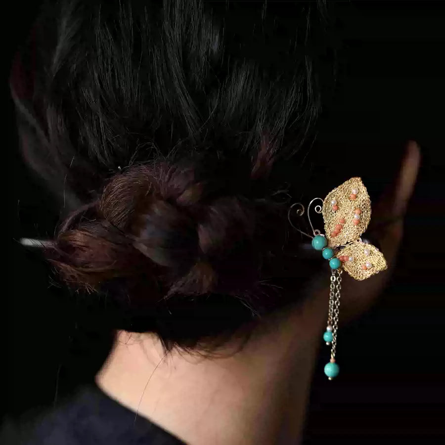 Gold butterfly hairpin styled in a hair bun