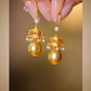 Pair of pavilion-inspired drop earrings shown close up